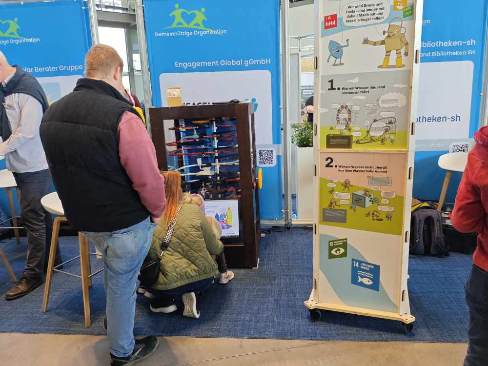 Kinder spielen die interaktive Murmelbahn zum Thema SDG 6